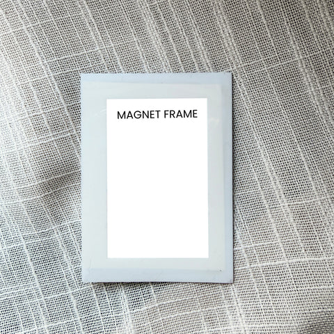Small white magnet frame on a textured gray background
